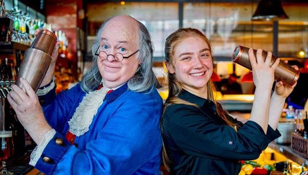 Benjamin Franklin impersonator at Red Owl shaking a cocktail with bartender